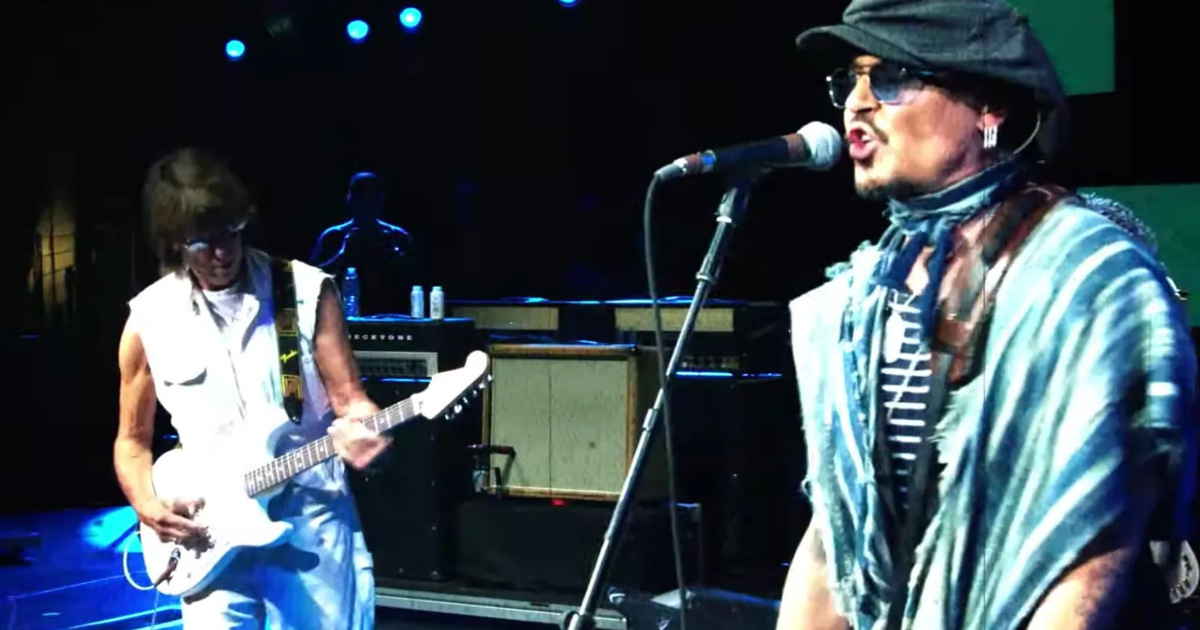 Johnny Depp singing beside Jeff Beck playing a white guitar on stage