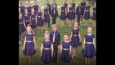 COLOR MUSIC children’s choir standing outdoors in navy outfits.