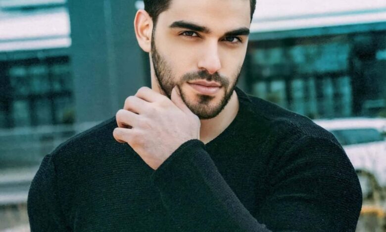 Turkish model Firat Zan wearing a black sweater in an outdoor portrait