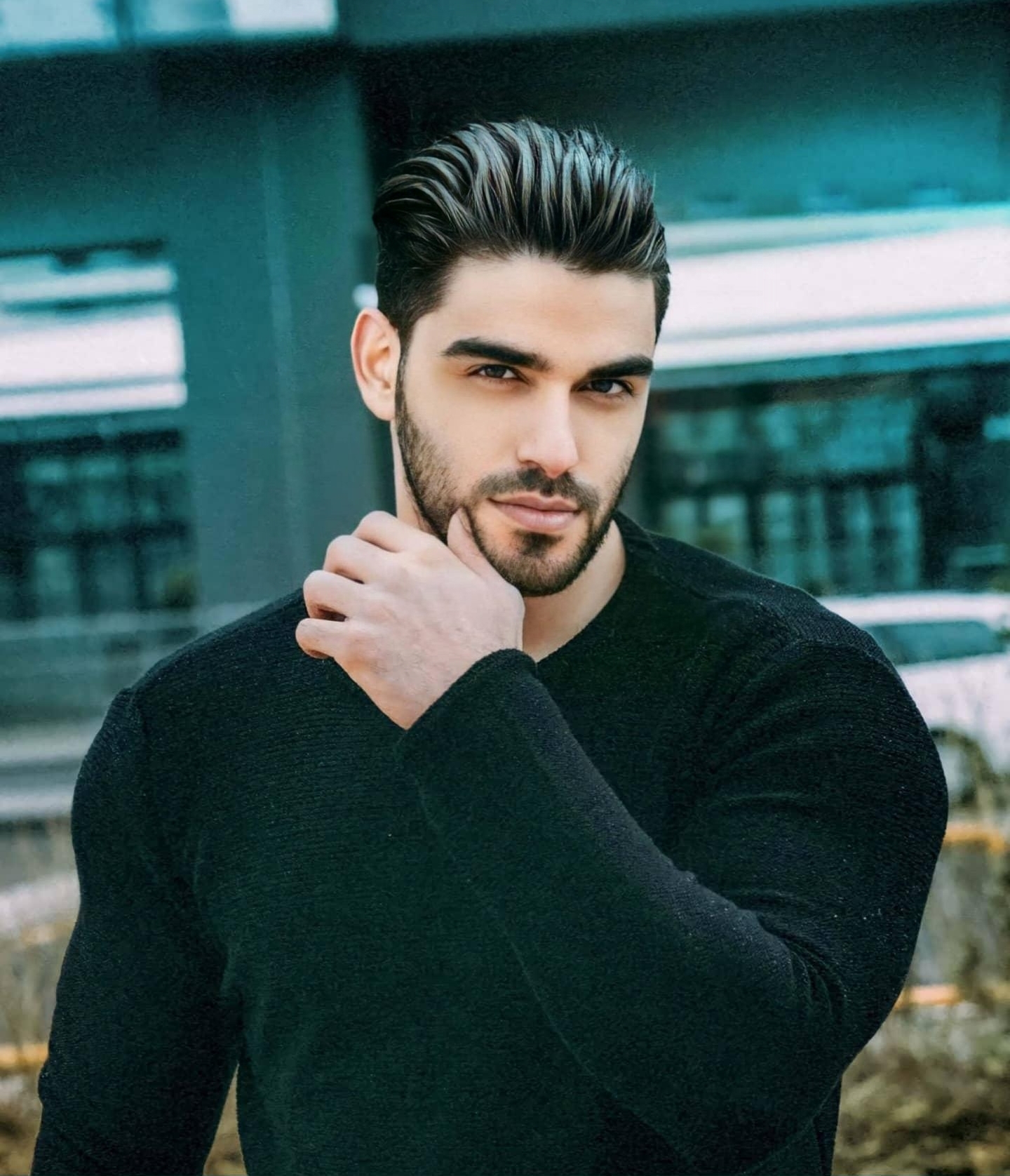 Turkish model Firat Zan wearing a black sweater in an outdoor portrait