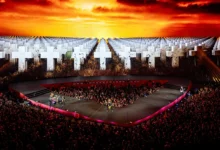 Metallica onstage at Sphere, with the audience beneath a screen showing white crosses and a fiery sky.